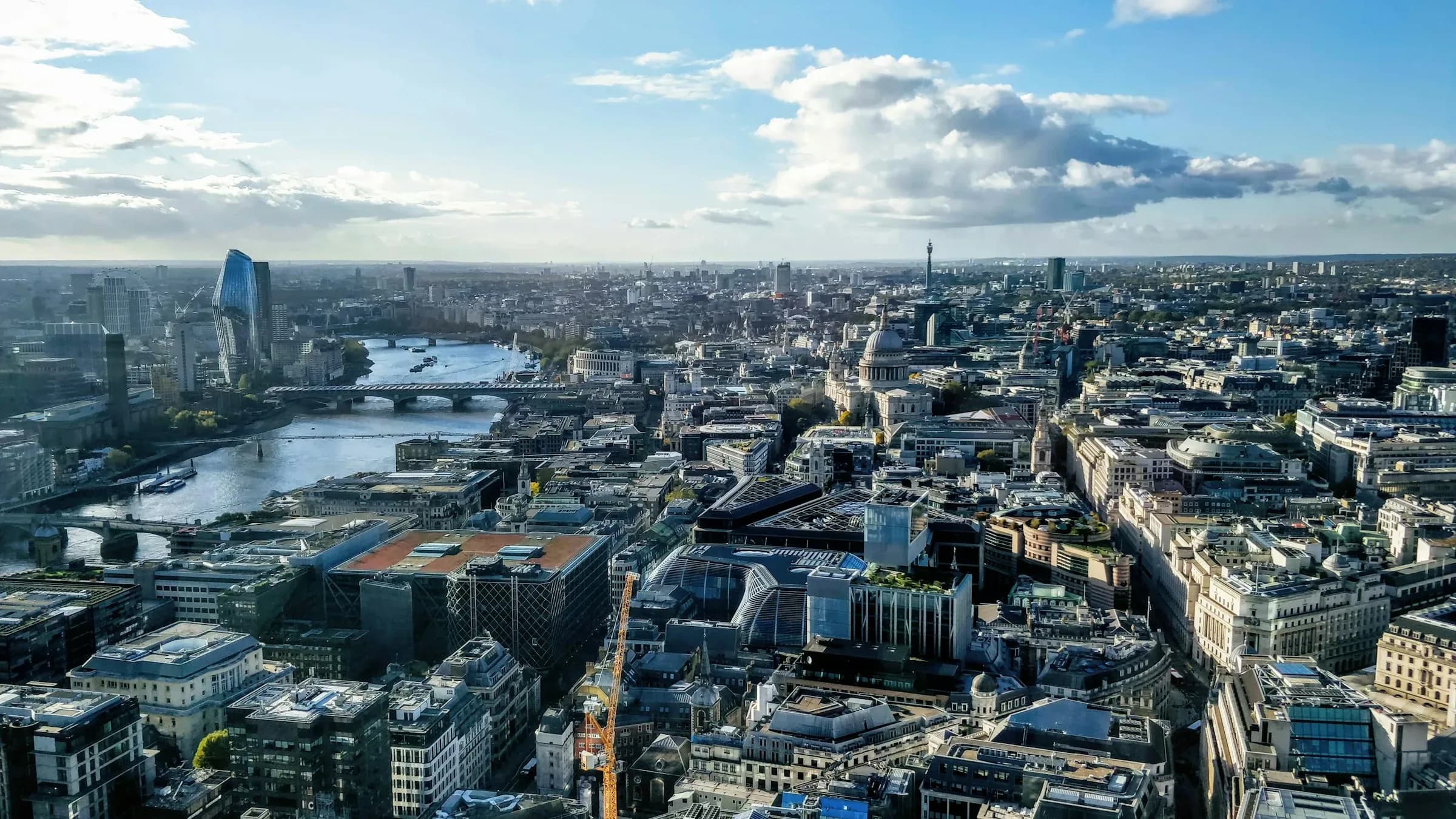 High-angle aerial view over central London with St Paul's Cathedral and the Thames — capital thesis and execution desk
